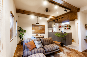 キッチンの腰壁は、コンクリートや石のような質感のモールテックス仕上げ。キッチン背面はタイル仕上げの壁に造作の古材棚